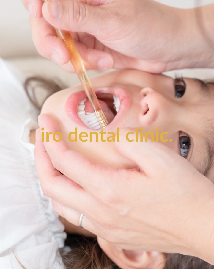 女の子が歯磨きをしてもらっている写真