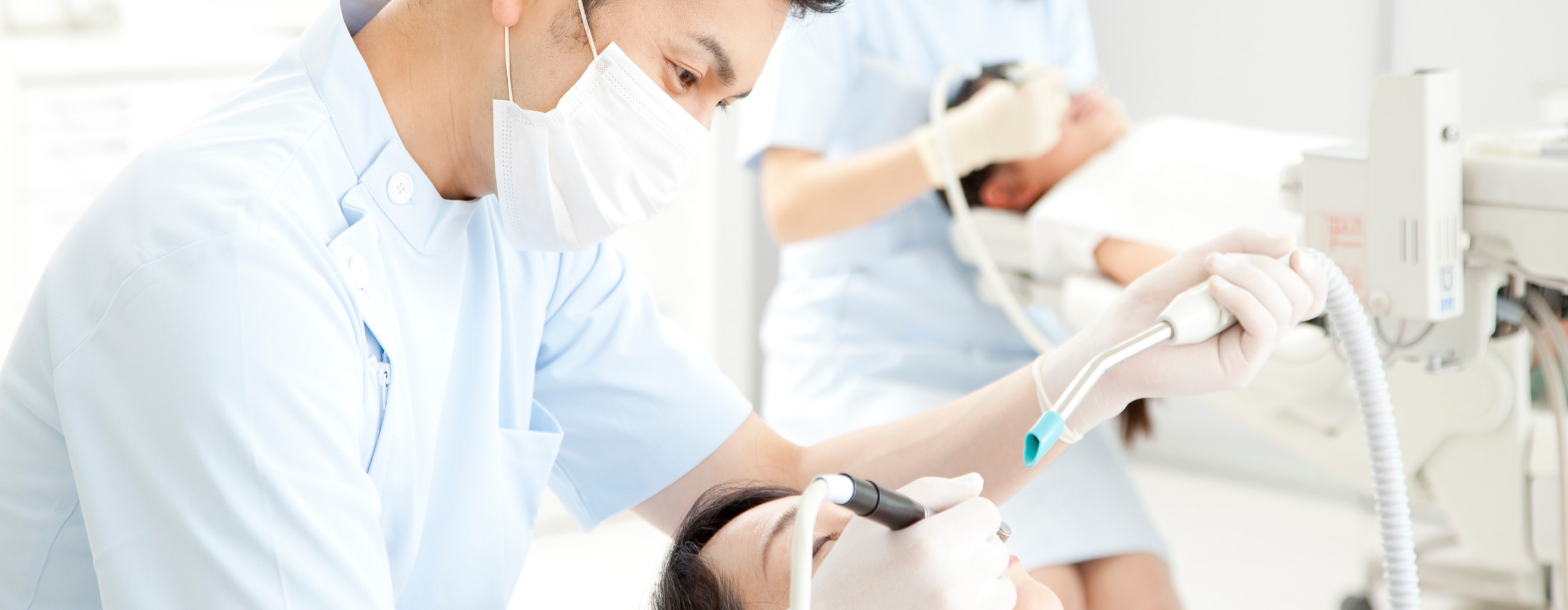 歯科医が器具を使用して治療している写真