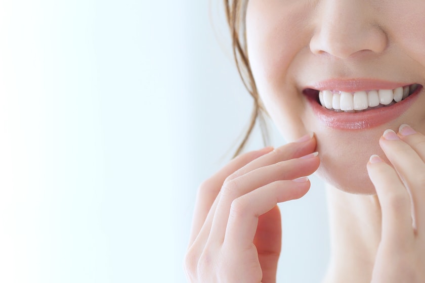 口元をアップで写した笑顔の女性の写真