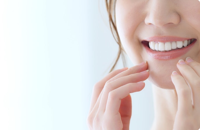 白い歯を見せて微笑む女性の口元の写真